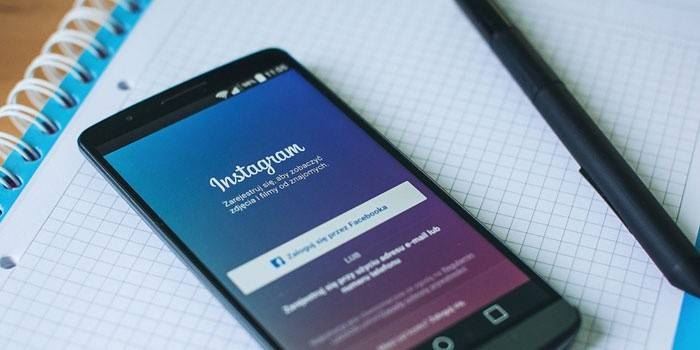Приложение Инстаграм на телефоне, блокнот и ручка
